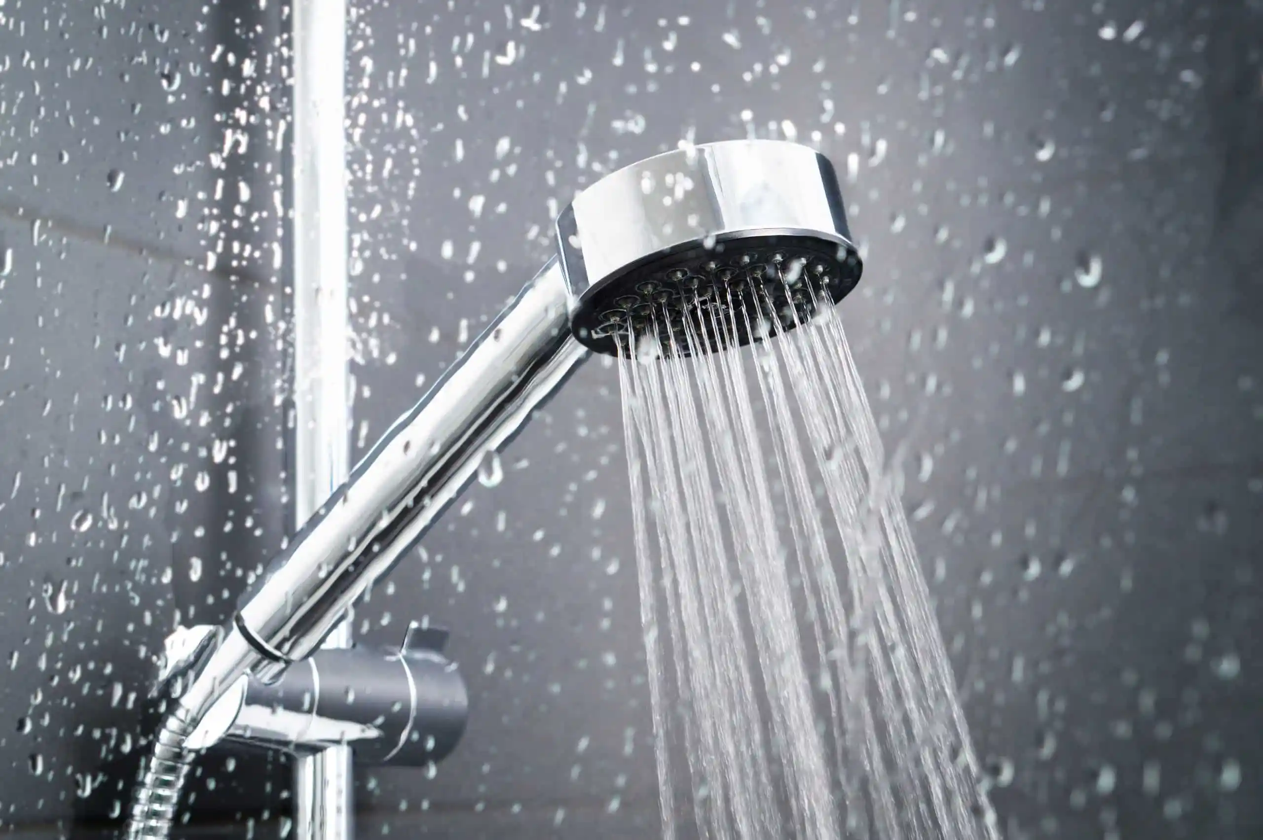 Fresh-shower-behind-wet-glass-window-with-water-drops-splashing.-917616066_5456x3632-scaled